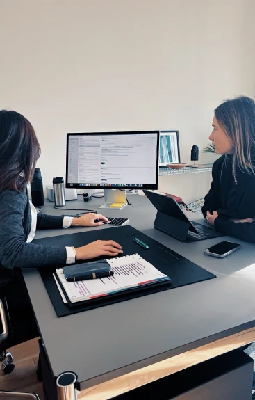 Deux collaboratrices travaillant ensemble sur la création d'entreprise, illustrant l'accompagnement exhaustif offert par un cabinet d'expertise comptable à chaque étape du processus.