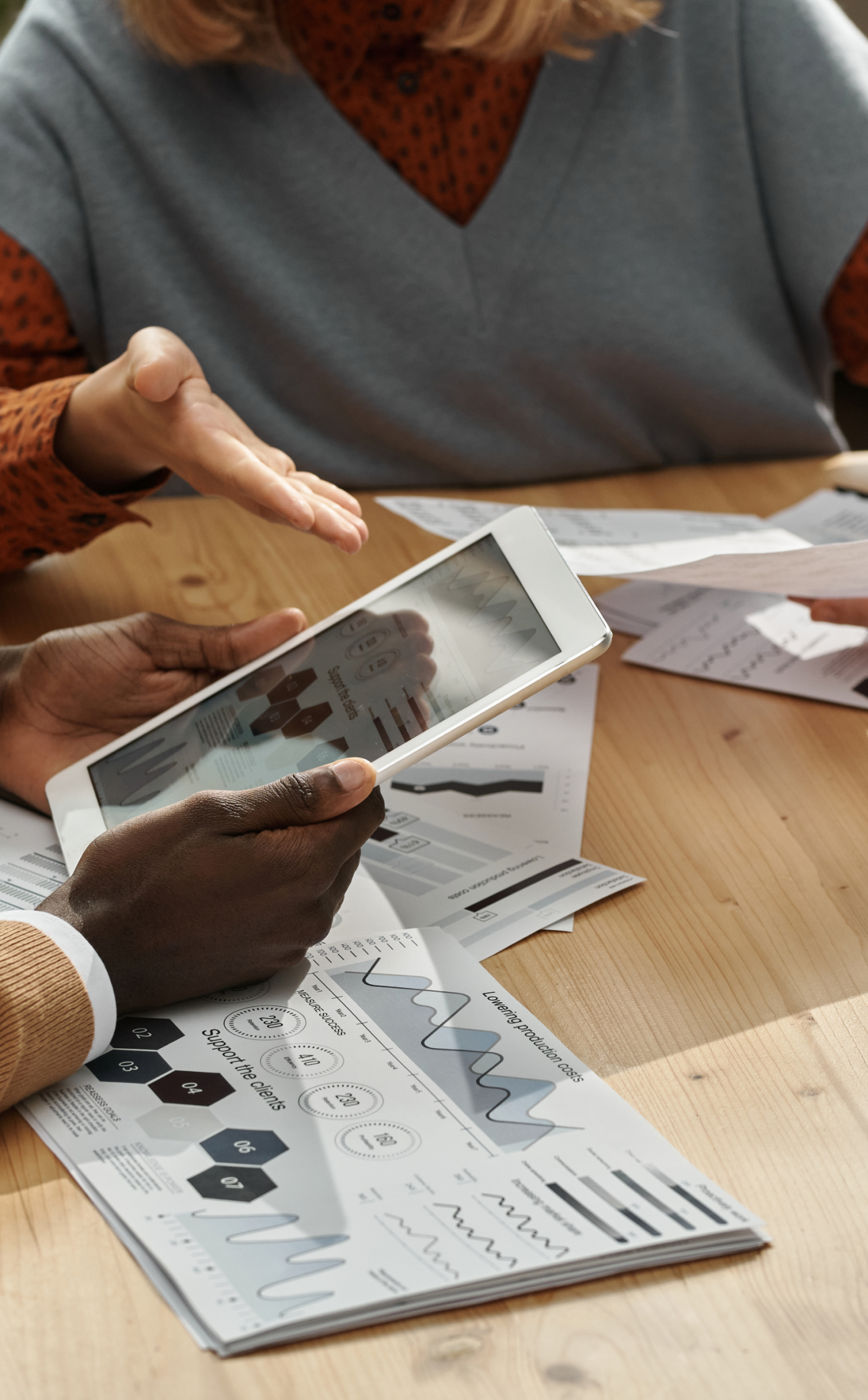 deux personnes qui regardent des diagrammes sur une tablette et des feuilles de papiers