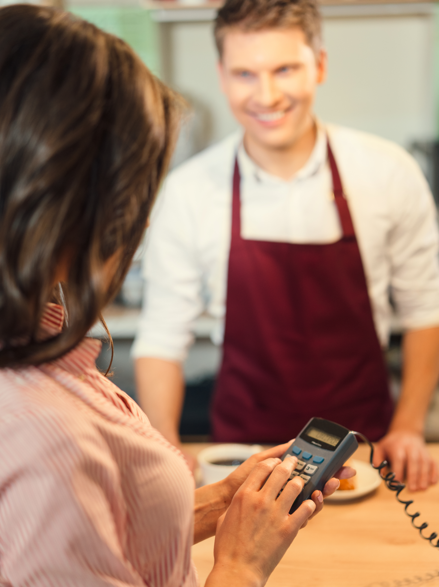 Interaction entre une commerçante et un client, symbolisant la gestion des commerces accompagnés par OVCE