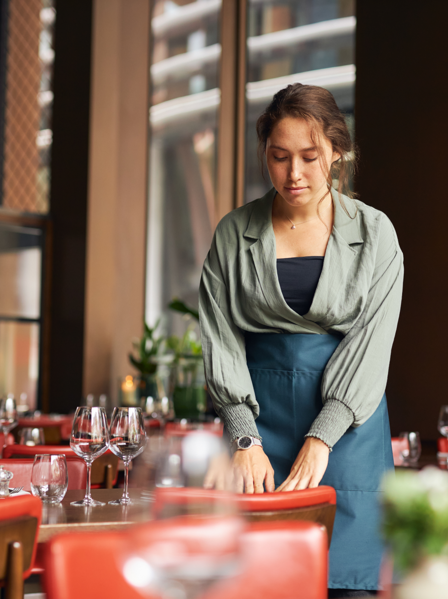 Une collaboratrice en salle dans un restaurant, bénéficiant des services d’accompagnement d’OVCE pour son activité